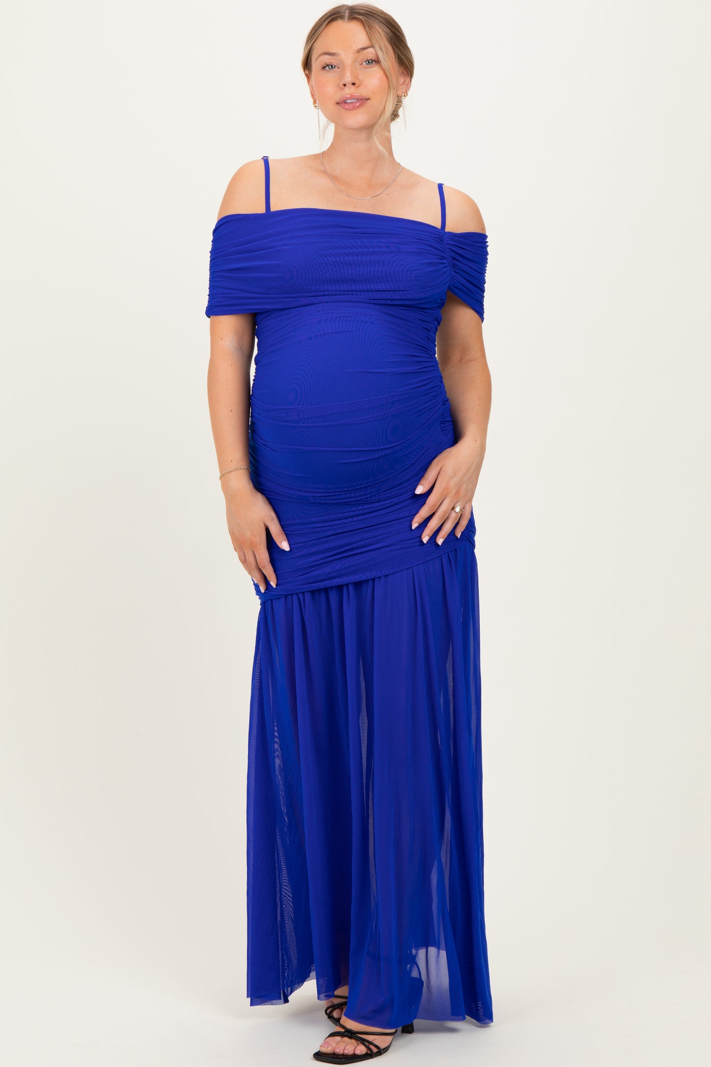 woman wearing a royal blue maternity dress with off-the-shoulder sleeves and a flowy skirt, showcasing her baby bump