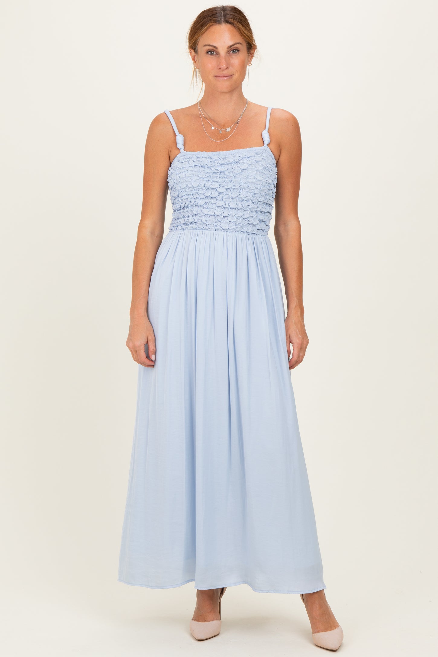woman wearing a light blue smocked maxi dress with spaghetti straps and a flowy skirt
