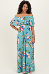woman wearing a teal off-the-shoulder floral maxi dress with large pink and blue flowers