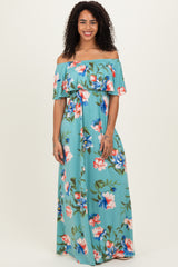 woman wearing a light blue off-the-shoulder maxi dress with floral print and flowing silhouette