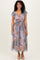 woman wearing a floral print maxi dress with ruffled sleeves and a cinched waist, standing against a neutral background