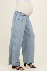 woman wearing light blue wide-leg maternity jeans with a stretchy beige waistband and visible baby bump