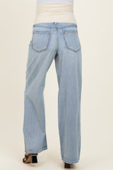 woman wearing light wash maternity jeans with a wide-leg style and an elastic pregnancy-friendly waistband