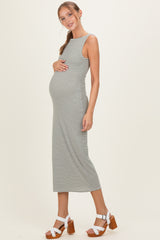 woman wearing a striped maternity dress that hugs her baby bump, paired with white sandals