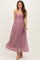 woman wearing a floral pink maternity maxi dress with a fitted bodice and flowing skirt, showing her baby bump