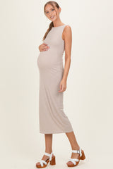 woman wearing a brown and cream striped maternity dress with a fitted silhouette, highlighting her baby bump