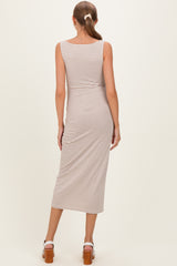 woman wearing a striped beige and white maternity midi dress, showing the back view and a fitted silhouette