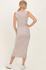 woman wearing a striped midi tank dress with a fitted silhouette and side slit, facing away from the camera