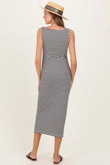 woman wearing a black and white striped maternity maxi dress, standing with her back facing the camera