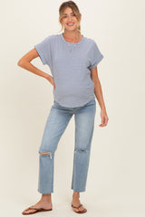 woman wearing a navy and white striped maternity t-shirt and distressed light wash jeans, showing her baby bump
