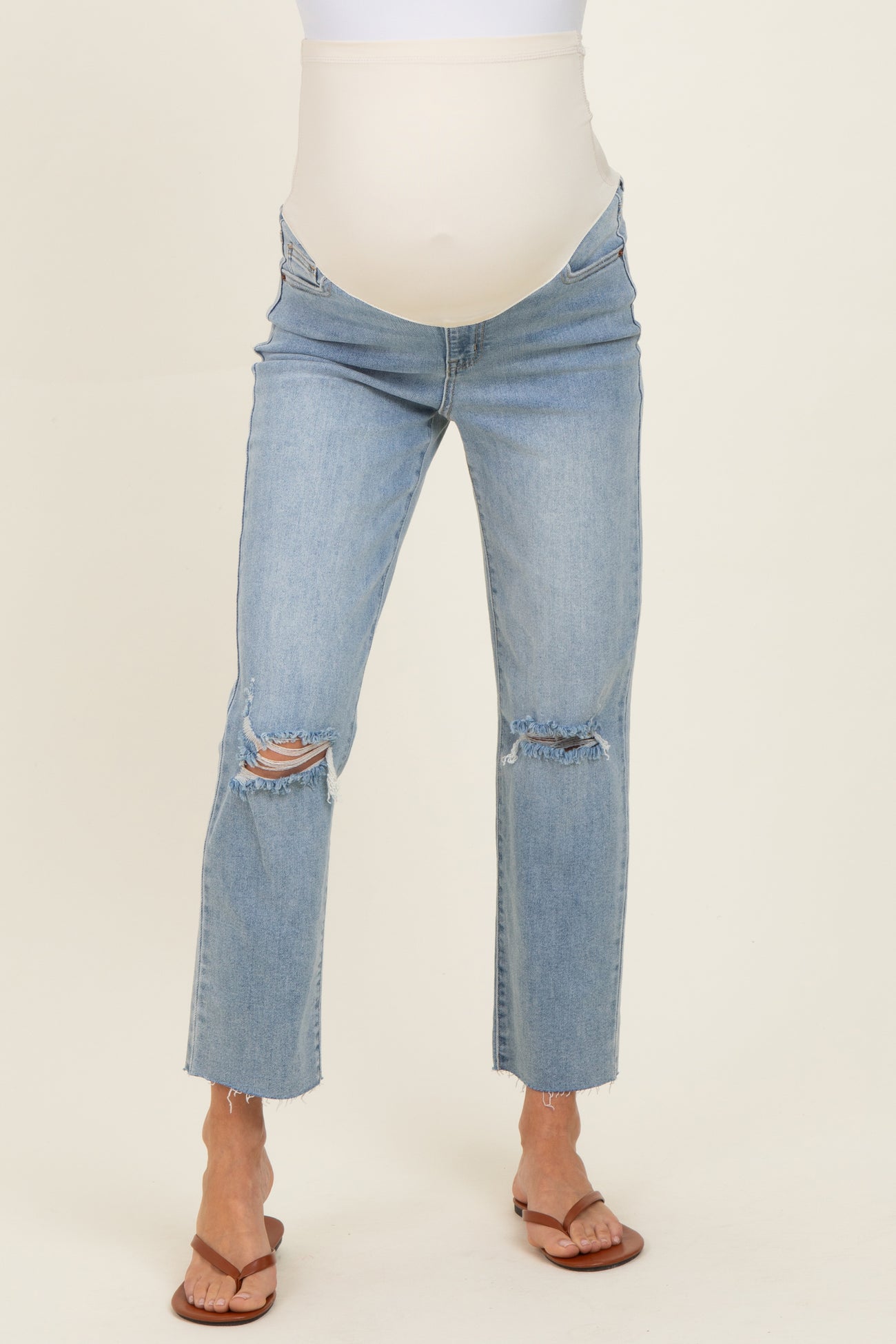 woman wearing distressed light blue maternity jeans with a supportive belly panel