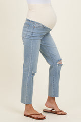 woman wearing light blue maternity jeans with a distressed style and a supportive over-the-bump waistband, showing a baby bump