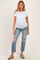 woman wearing a white short sleeve maternity top and distressed light blue maternity jeans with a visible baby bump