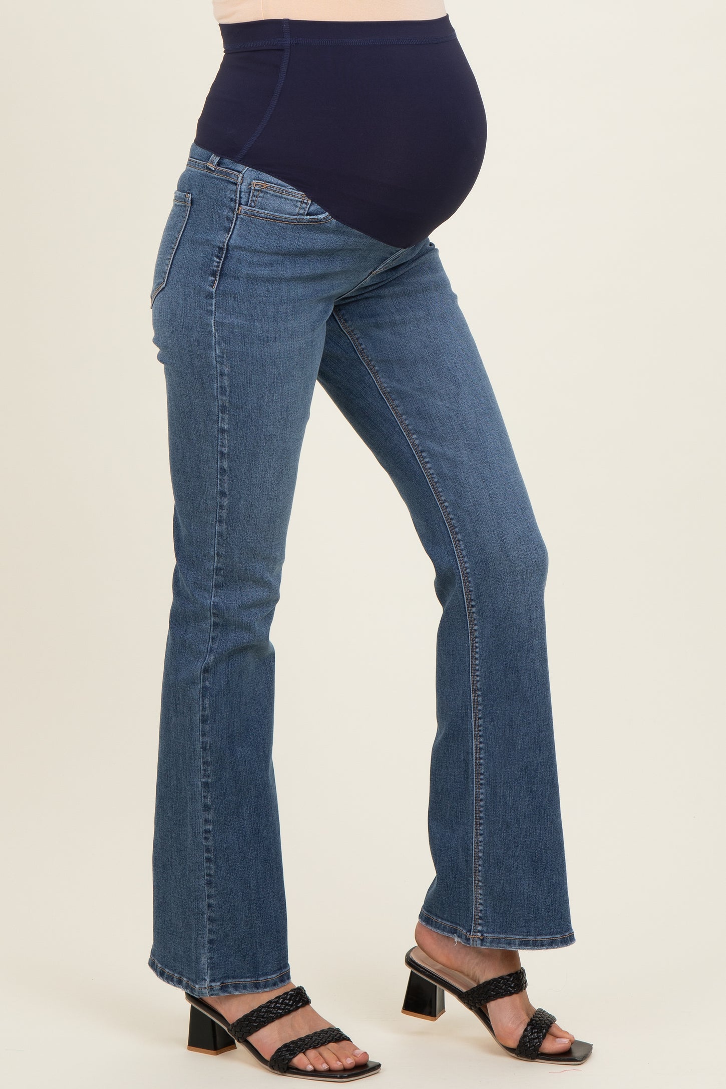 woman wearing a pair of blue maternity jeans with a comfortable belly panel and a visible baby bump