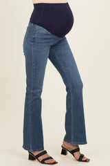 woman wearing a pair of blue maternity jeans with a comfortable belly panel and a visible baby bump