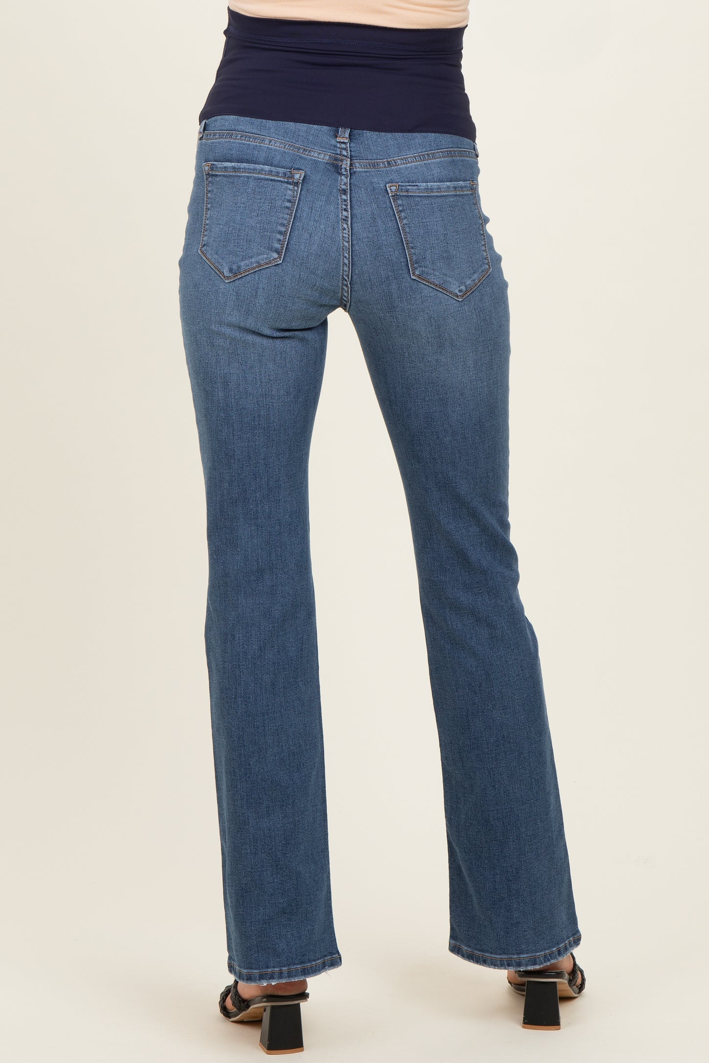 woman wearing dark wash maternity jeans, viewed from the back, showing straight leg and elastic waistband