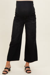 woman wearing black wide-leg maternity jeans with a soft belly panel and a visible baby bump