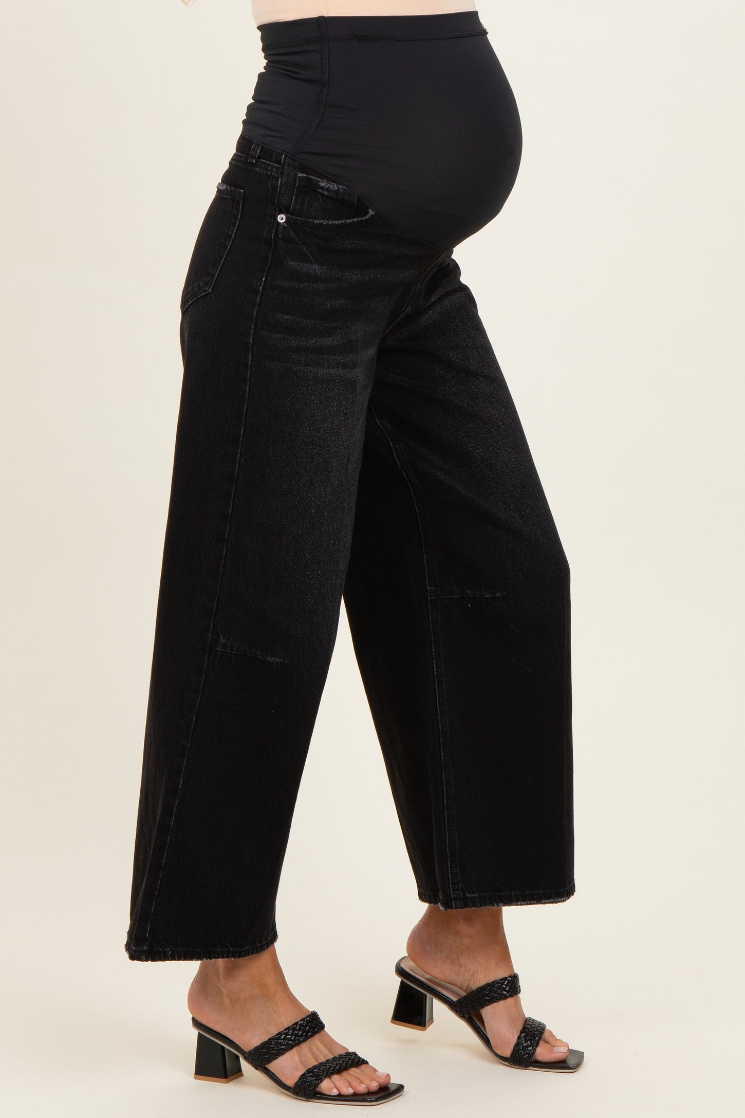 maternity wear black wide leg jeans with a stretchy waistband, worn by a woman showing her baby bump