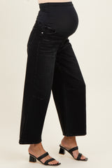 maternity wear black wide leg jeans with a stretchy waistband, worn by a woman showing her baby bump