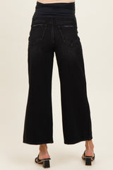 woman wearing black wide leg maternity jeans, showing the back view, with a fitted black top