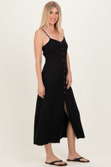 woman wearing a black maxi dress with spaghetti straps and a button-down front and a side slit