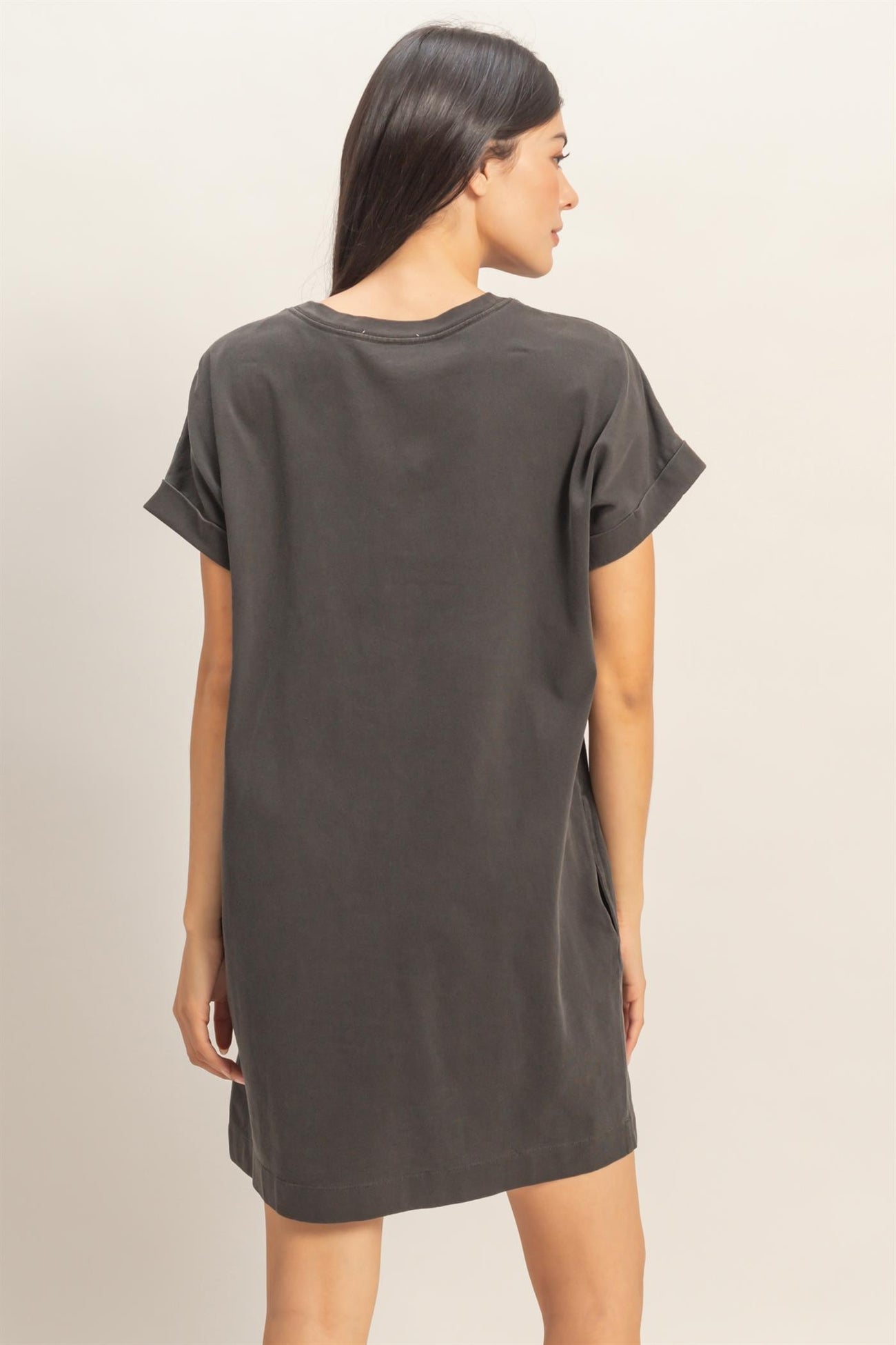 woman wearing a dark grey oversized t-shirt dress, viewed from the back with short sleeves
