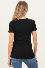 woman wearing a black short sleeve maternity top, viewed from the back with a slim fit silhouette