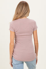 woman wearing a light mauve ribbed maternity top, showing the back view