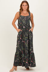 woman wearing a black floral maxi dress with pockets and ruffled hem