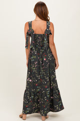 woman wearing a black floral maxi dress with a smocked back and bow detail on the straps
