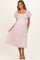 woman wearing a pink floral maternity maxi dress with puff sleeves and tiered skirt, showing her baby bump