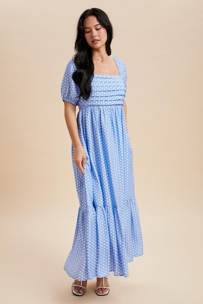 woman wearing a blue polka dot maxi dress with a square neckline and puff sleeves