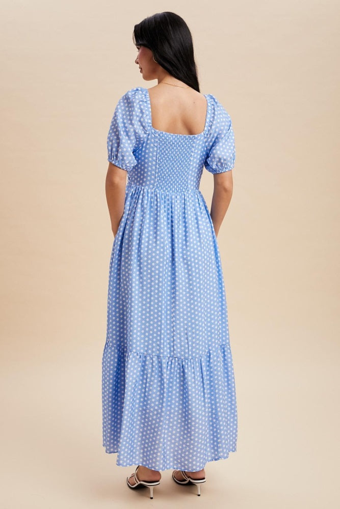 woman wearing a blue polka dot maxi dress with puff sleeves and a square back design