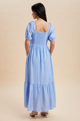woman wearing a blue polka dot maxi dress with puff sleeves and a square back design