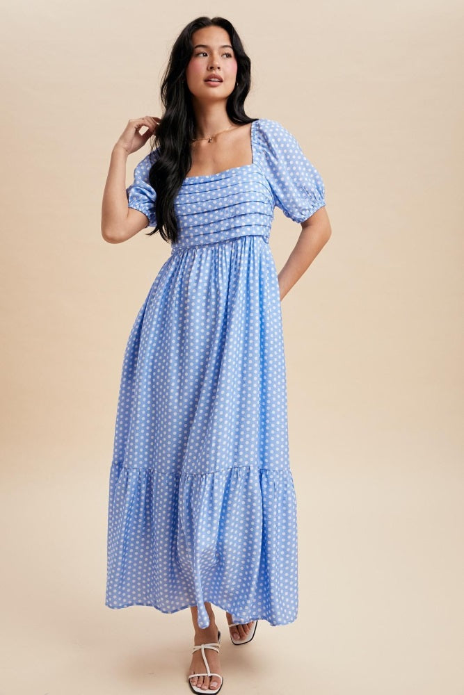 woman wearing a blue polka dot maxi dress with puff sleeves and a square neckline