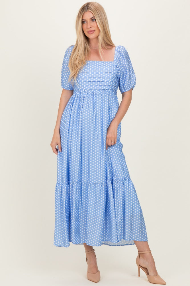 woman wearing a blue polka dot maxi dress with puff sleeves and a square neckline, standing in light-colored heels