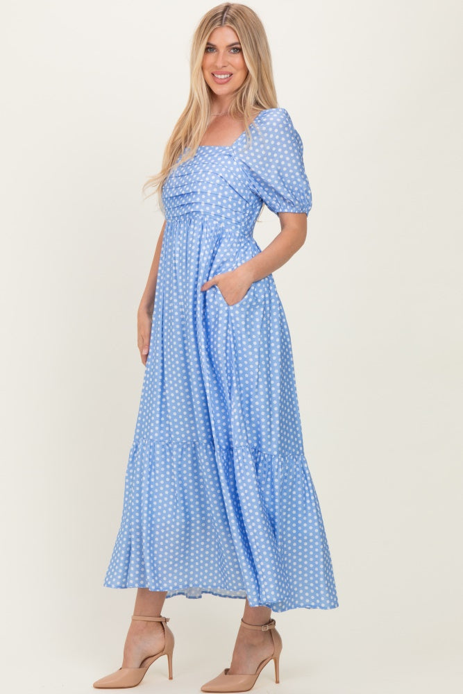 woman wearing a blue polka dot maxi dress with puff sleeves and pockets