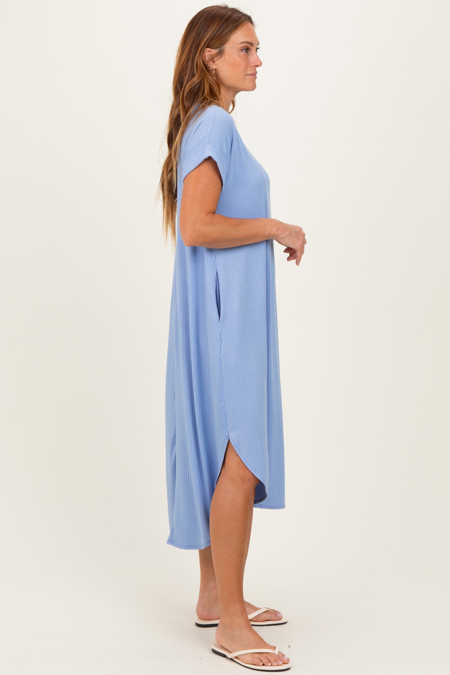 woman wearing a light blue short sleeve maxi dress with side slits and a relaxed fit