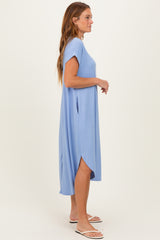 woman wearing a light blue short sleeve maxi dress with side slits and a relaxed fit