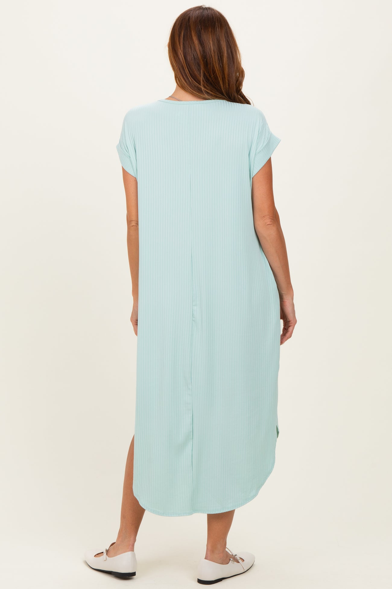 woman wearing a light blue short sleeve maxi dress with a relaxed fit and side slits, seen from the back