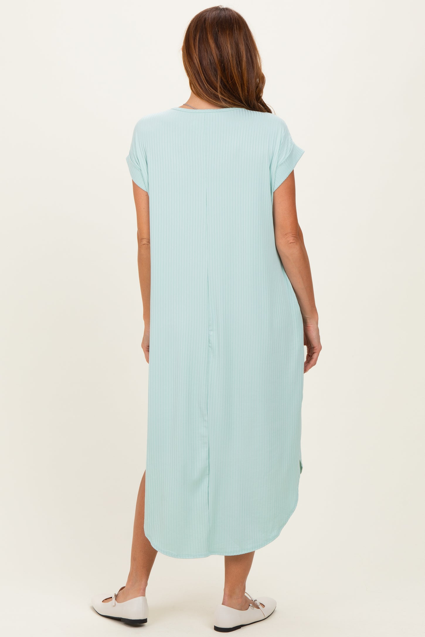 woman wearing a light blue short sleeve maxi dress with a relaxed fit and side slits, seen from the back