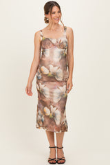 woman wearing a floral print maternity dress with a fitted silhouette and spaghetti straps, showcasing a baby bump