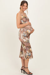 woman wearing a floral print maternity dress with a fitted silhouette and holding her baby bump