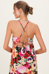 woman wearing a colorful floral maternity dress with a crisscross back and adjustable tie detail