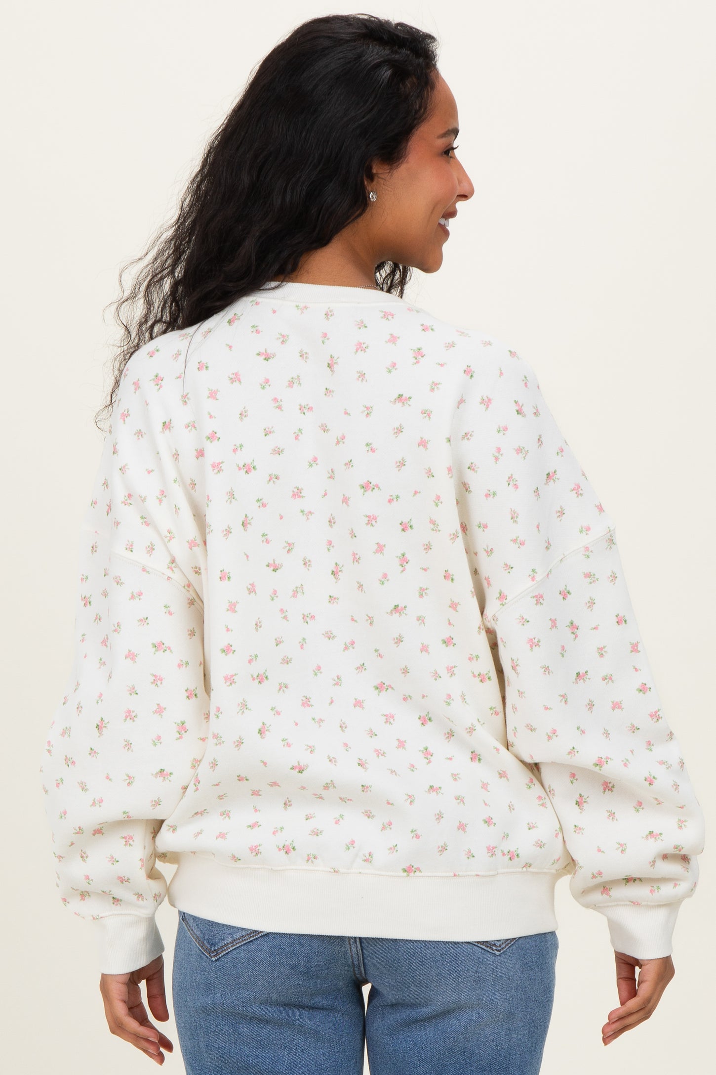 woman wearing a floral print maternity sweatshirt with a cozy fit and a round neckline, showing the back view