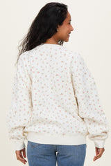 woman wearing a floral print maternity sweatshirt with a cozy fit and a round neckline, showing the back view
