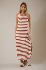 woman wearing a sleeveless cream and red striped maxi dress with side slits and sandals