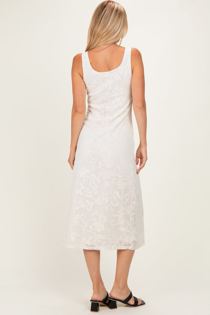 woman wearing a white sleeveless lace midi dress, showing a floral design and back view