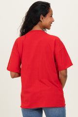 woman wearing a red oversized maternity t-shirt, showing the back view and relaxed fit