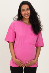 woman wearing a bright pink short sleeve maternity t-shirt with a pocket, holding her baby bump